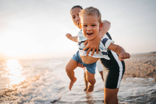 istock Mom is playing with her son on the beach 1345688296