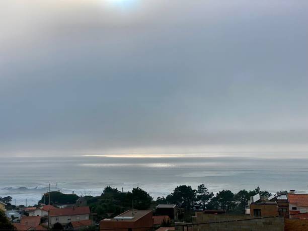 Panorama of gray clouds with sun over ocean. High angle view of ocean coastline with gray sky and sunbeams. Portugal. Autumn day. stratus clouds stock pictures, royalty-free photos & images