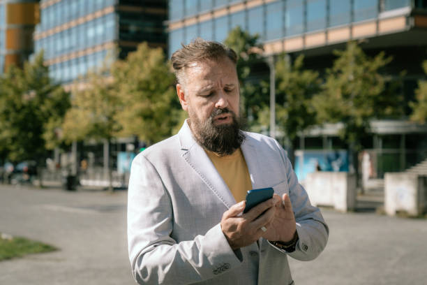 istock Mature businessman texting on cell phone 1345691545