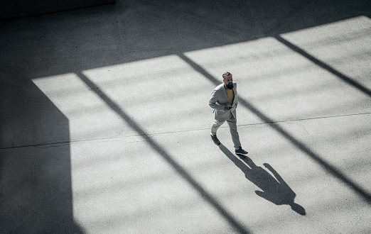 High angle view of a businessman walking outdoors. Male business professional commuting.