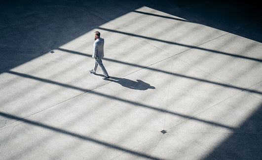 High angle view of a businessman walking outdoors. Male business professional commuting.