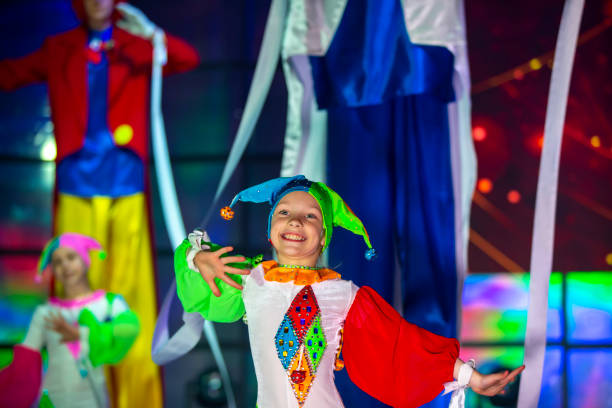 la petite fille danse dans un costume de clown. l’enfant se produit sur scène. - class clown photos et images de collection