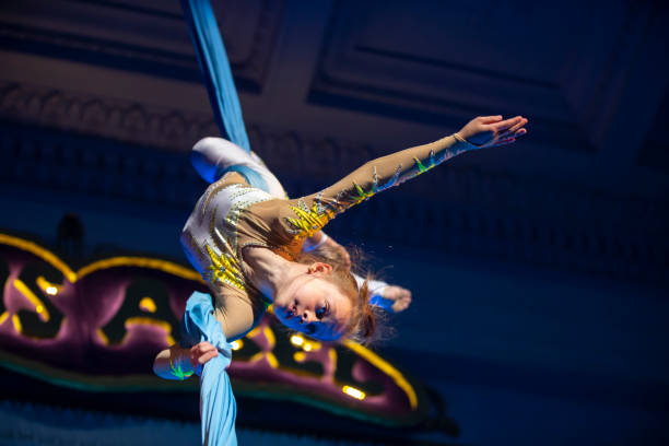 istock The girl performs acrobatic numbers on the canvases. A small circus artist performs on the canvases of acrobats. Child perform acrobatic elements in the air 1345692746