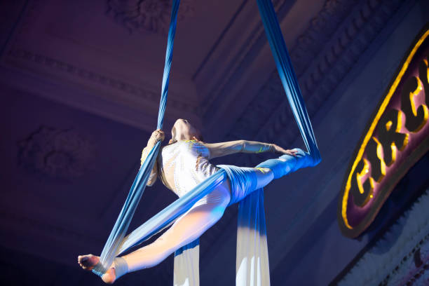 istock The girl performs acrobatic numbers on the canvases. A small circus artist performs on the canvases of acrobats. Child perform acrobatic elements in the air 1345692749