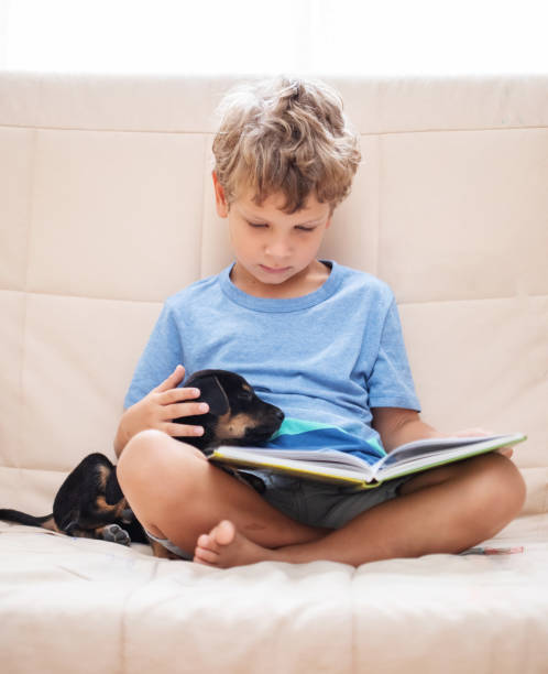 istock A boy with a little dog is reading a book in Ukraine 1345693385