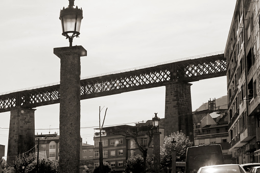 The old metal bridge above the river surrounded by green vegetation.