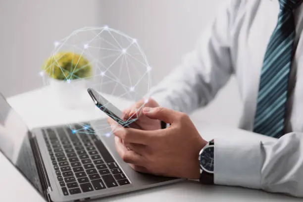 Photo of Businessman downloading in mobile store popular applications and multimedia programs. Man hands using a device at a co-working office.