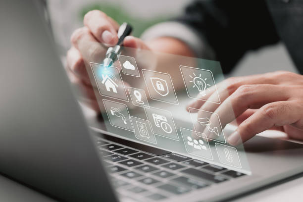 istock Man and laptop with futuristic interface of smart home automation assistant on a virtual screen and a user touching a home button. 1345697553