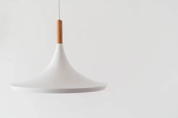 Photo of Modern ceiling lamp hanging against white wall