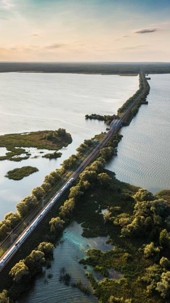 istock Passenger train drives on a railroad track through the river 1345700188