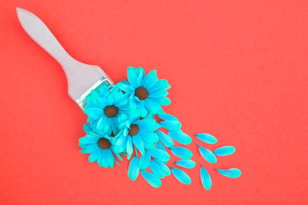 istock Paintbrush  with blue flowers  on the red background. Top view. Copy space 1345704961