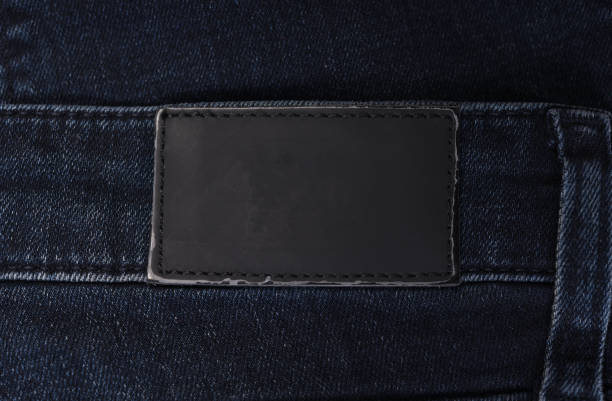 l'etichetta di abbigliamento dice primo piano del denim sui blue jeans - leather patch denim jeans foto e immagini stock