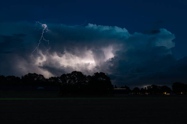 istock Lightning bolt jumps out of the storm cloud during blue hour 1345707965