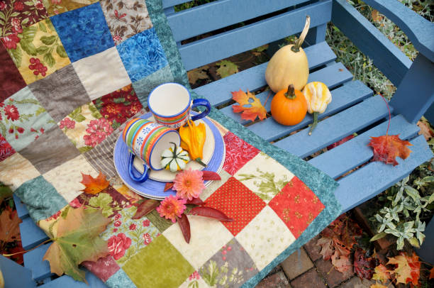 istock Backyard fall harvest decorations on sheltered patio swing bench with cozy blankets for cool autumn days and hot beverage 1345708172