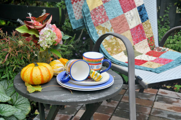 istock Backyard fall harvest decorations on sheltered patio swing bench with cozy blankets for cool autumn days and hot beverage 1345708331