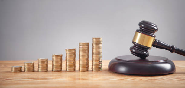 istock Stack of coins with judge gavel. 1345710414