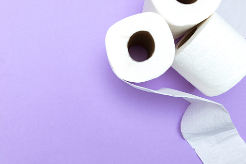 Directly above view of toilet papers on purple background.