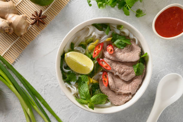 istock Pho Bo Soup with beef in white bowl on light backgound. Vietnamese cuisine. 1345713642