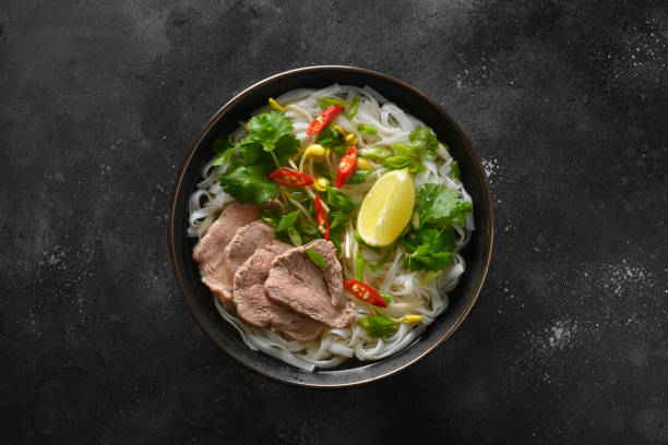 istock Pho Bo Soup with beef in bowl on black backgound. Vietnamese cuisine. 1345713647