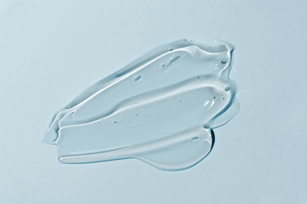 Liquid gel smear isolated on blue background. Beauty cosmetic smudge such as pure transparent aloe lotion, facial jelly serum, cleanser, shower gel or shampoo top view Liquid gel smear isolated on blue background. Beauty cosmetic smudge such as pure transparent aloe lotion, facial jelly serum, cleanser, shower gel or shampoo top view. shower gel stock pictures, royalty-free photos & images
