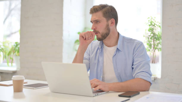 istock Young Creative Man having Coughing in Modern Office 1345717354