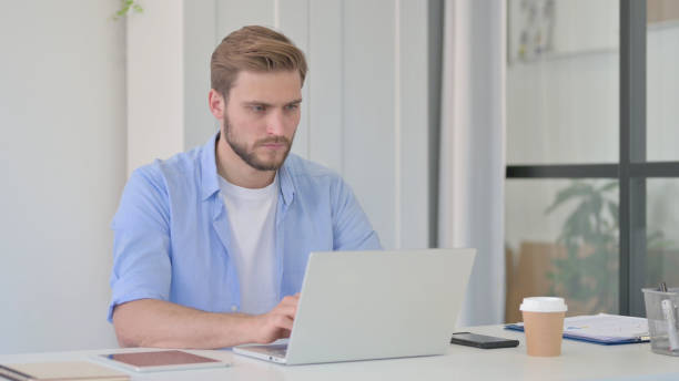 istock Young Creative Man Working on Laptop in Office 1345717412