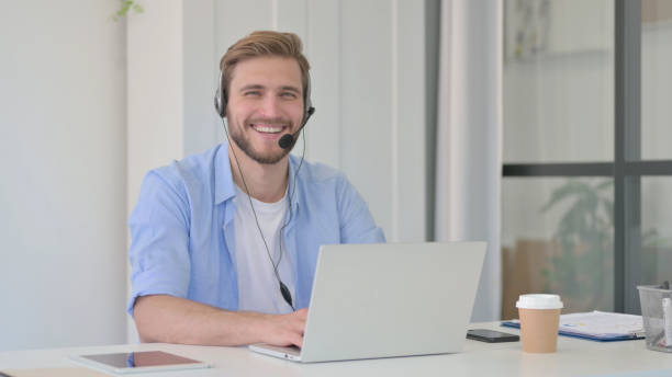 istock Creative Man with Headset and Laptop Smiling at Camera 1345718311