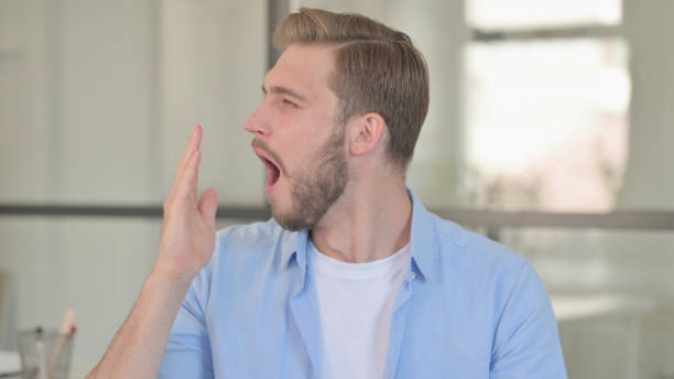istock Portrait of Sleeping Young Creative Man Yawning 1345718826