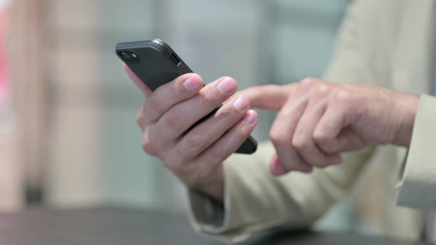 istock Close up of Man Browsing Internet on Smartphone 1345720667