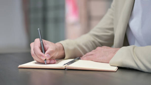istock Close up of Man Writing on Notebook 1345720971