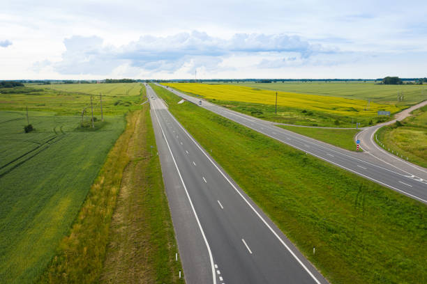 istock Asphalt highway through green summer field. Aerial view 1345721847