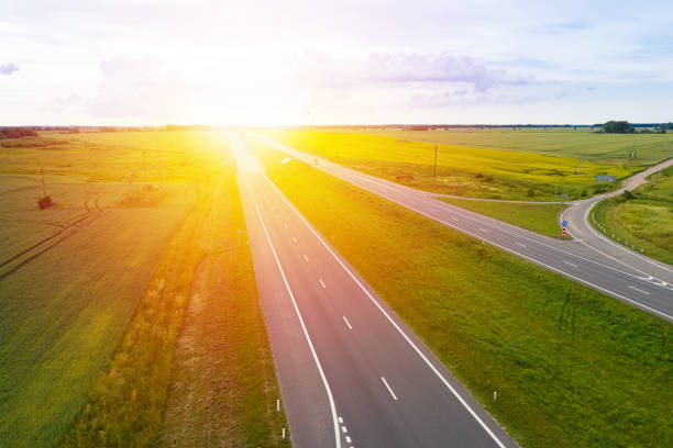 istock Asphalt highway through green summer field. Sunset time . Aerial view 1345721878