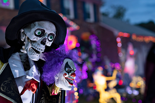 Close-up of skeleton ringmaster in the forefront of a yard, festively decorated for Halloween