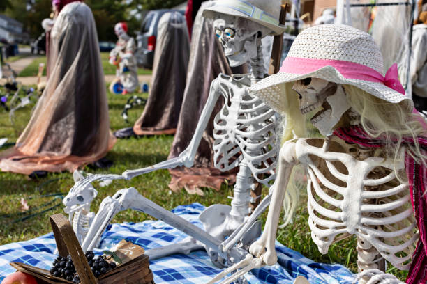 Playful scene of pretend couple on a picnic with their pet as part of a large yard of Halloween decorations