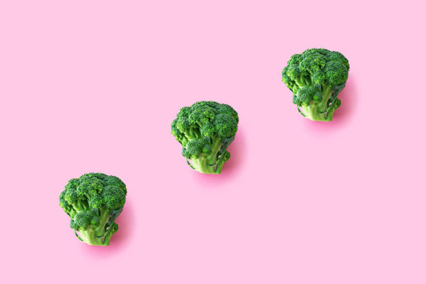istock Fresh green broccoli on pink background 1345722429