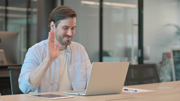 istock Casual Young Man Talking on Video Chat on Laptop 1345722981