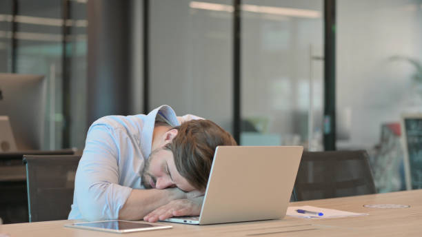 istock Casual Young Man with Laptop sleeping in Office 1345723136