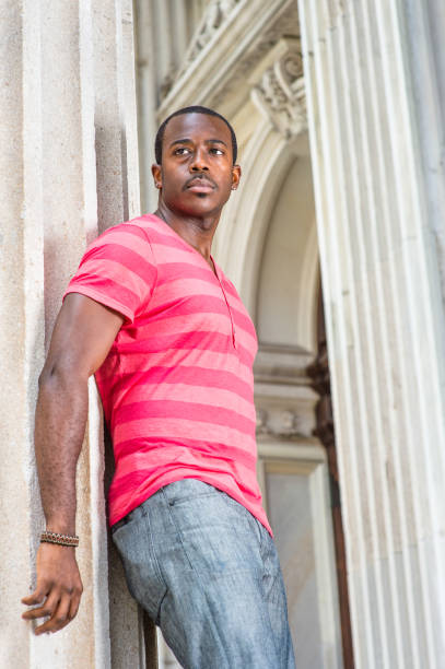 istock Young black man standing outside office in New York City, looking forward. 1345725839