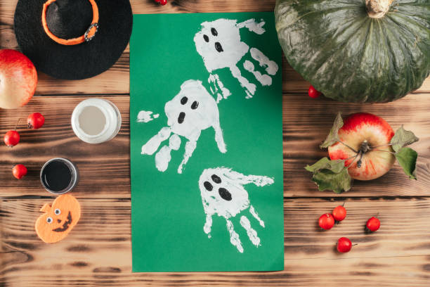 Step-by-step Halloween tutorial ghosts child's handprint. Step 9: Finished drawing of ghosts. Top view stock photo