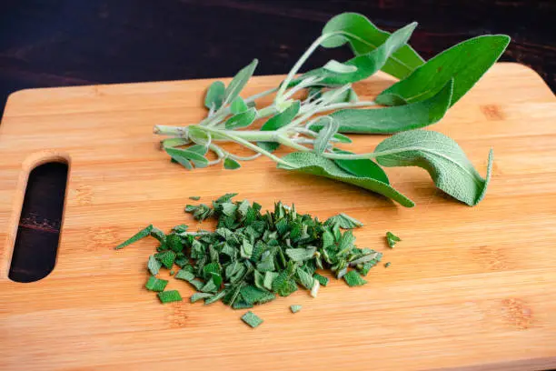 Minced sage leaves on a wooden cutting board