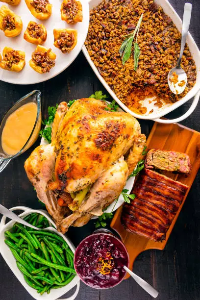 Roast turkey with gravy, sweet potato casserole, bacon-wrapped stuffing, green beans, cranberry sauce, and pecan pie bites