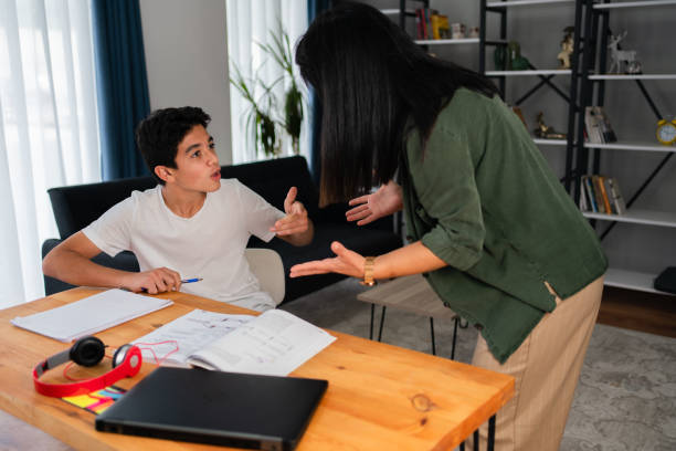 madre e suo figlio adolescente che discutono a casa - teenager laptop computer anger foto e immagini stock