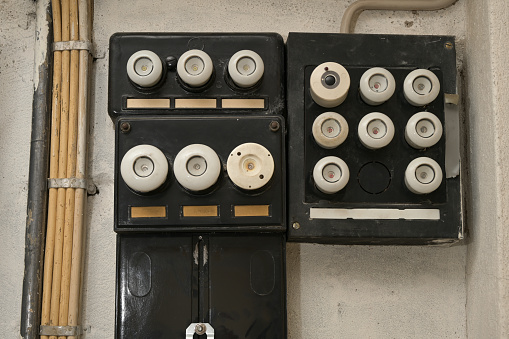 Old electrical fuse box with porcelain fuses in an older dwelling house, power and energy concept, selected focus