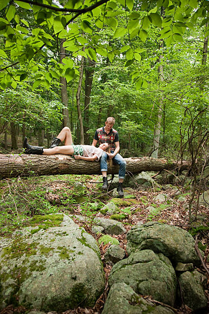 coppia rilassarsi insieme sul log nella foresta - tree harmony couple trust foto e immagini stock