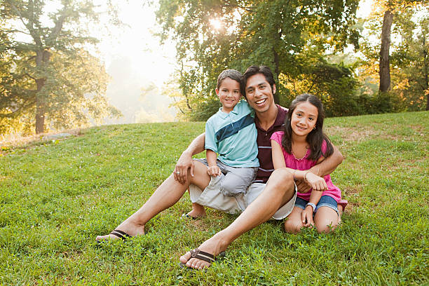 père assis avec des enfants dans le parc, portrait - family with two children family park child photos et images de collection