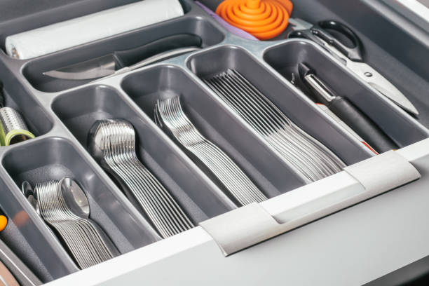 istock White kitchen cabinet open drawer with black cutlery organizer tray with silver forks, spoons, knives and accessories 1345736217