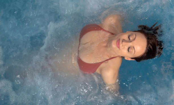 Top view of a woman relaxing at a spa pool hot tub Top view of a woman relaxing at a spa pool hot tub thermal pool stock pictures, royalty-free photos & images