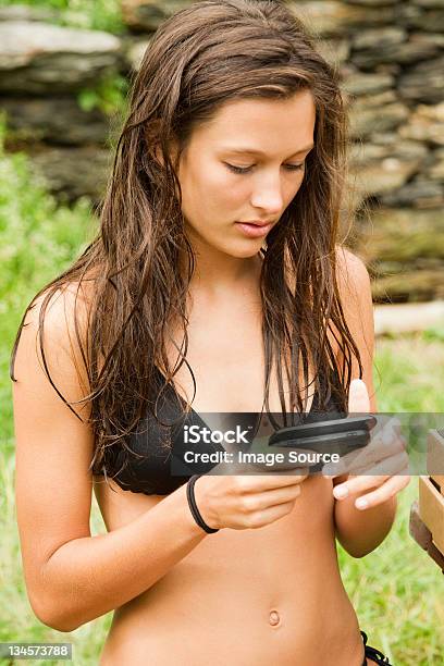 Teenage Girl Using Mobile Phone While Chilling Out Stock Photo - Download Image Now - Sensuality, Teenage Girls, Belly Button