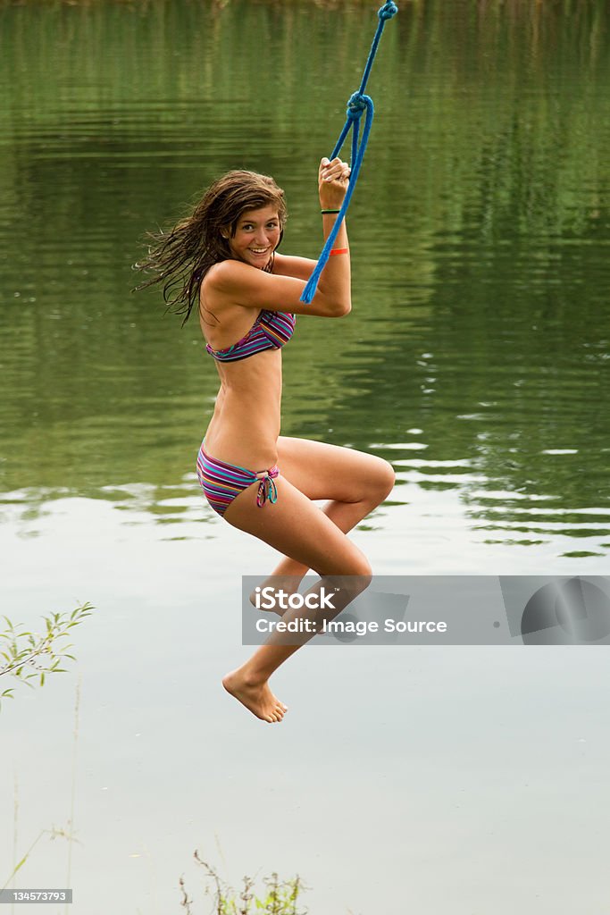 Girl swinging on a rope over a lake Austerlitz,New York,USA, Lake Stock Photo