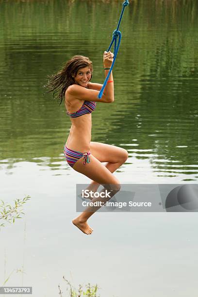 Girl Swinging On A Rope Over A Lake Stock Photo - Download Image Now - Lake, Rope Swing, 14-15 Years